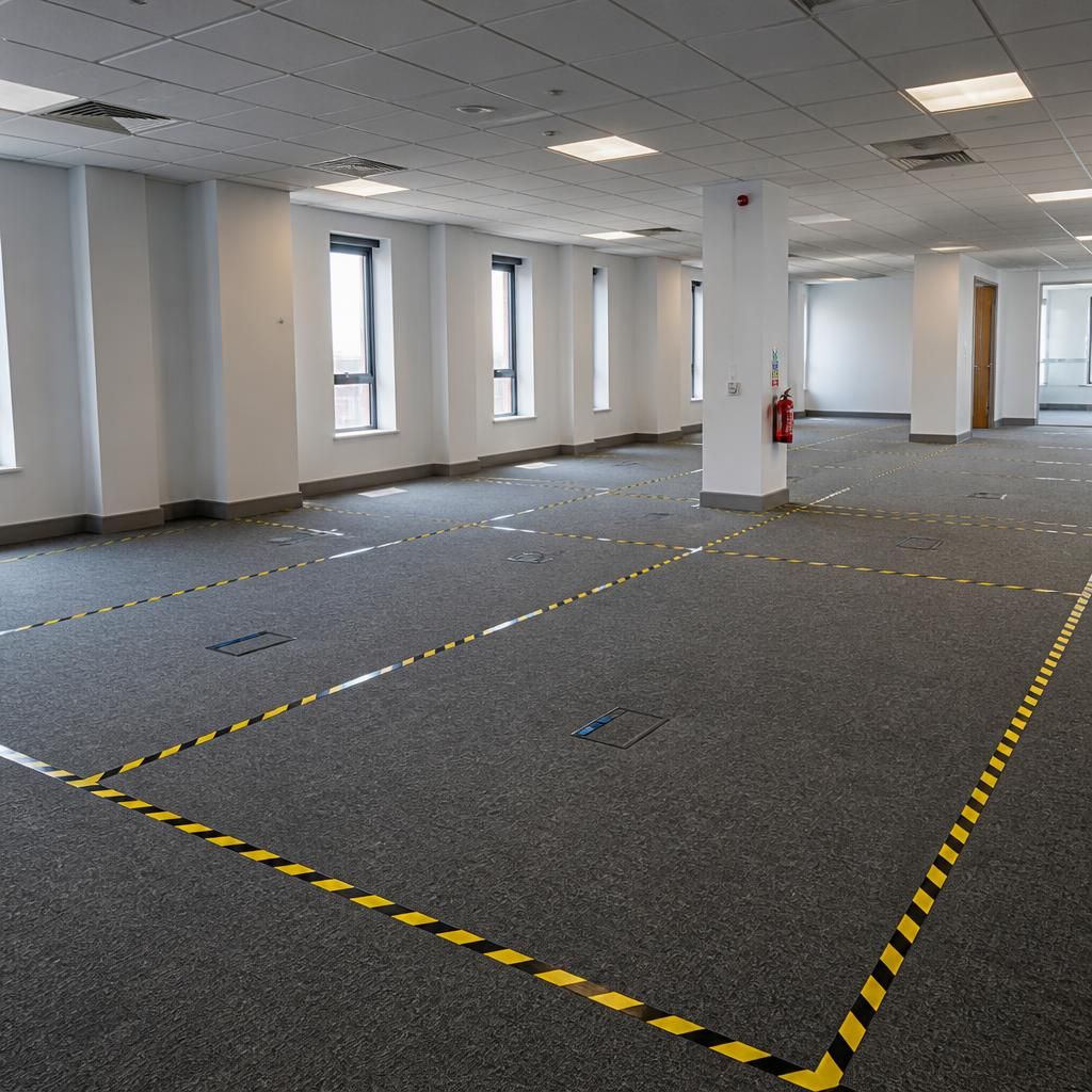 Cleared office with marked floor areas ready for furniture installation